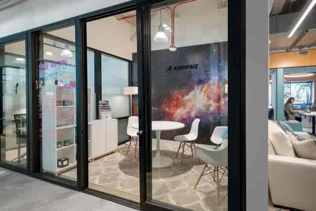 Modern meeting space with round table, galaxy backdrop for team brainstorming sessions.