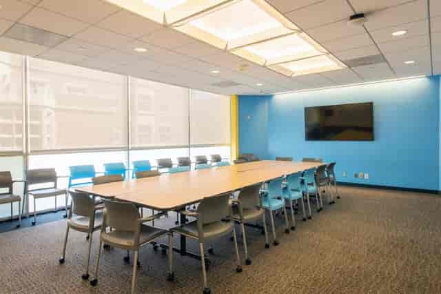 Modern meeting room with large table, ergonomic chairs, ideal for collaboration and presentations.