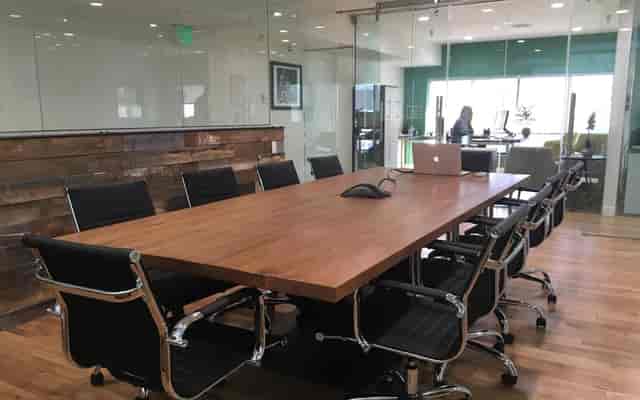 Modern conference room with wooden table, ideal for meetings and collaboration.