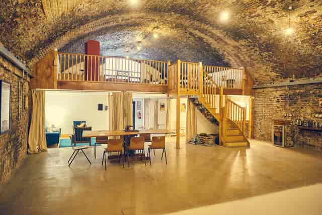 Rustic event space with exposed brick walls, ideal for corporate meetings and social events.