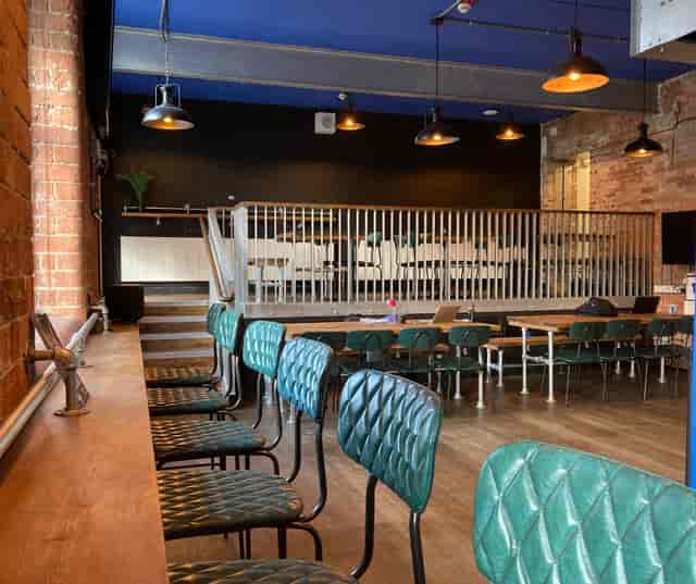 Versatile event space with elevated stage, ideal for corporate meetings and workshops.