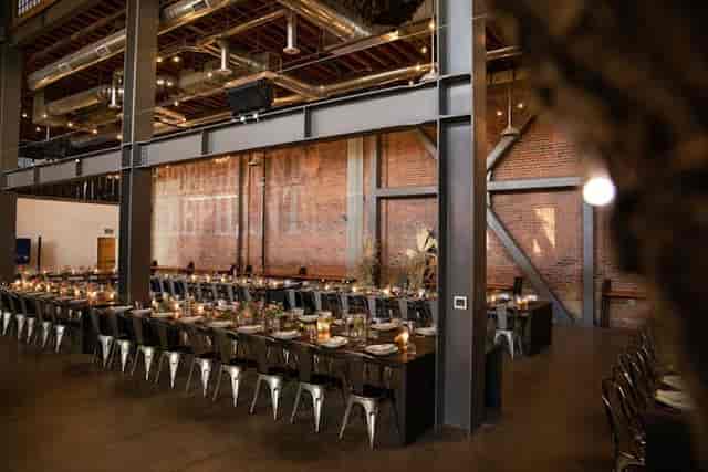 Spacious event venue with elegant dining table, ideal for corporate dinners and celebrations.