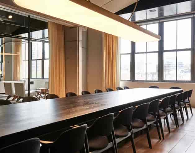 Modern meeting room with sleek table and natural light for corporate events.