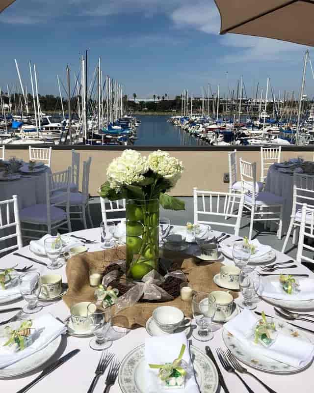Elegant outdoor banquet area with floral centerpieces, ideal for weddings and corporate events.