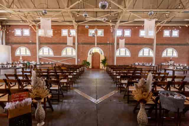 Rustic wedding venue with brick walls, elegant decor, and festive lighting.