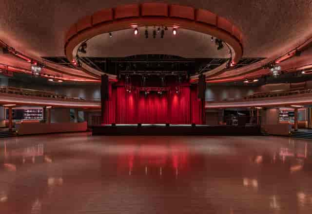 Hollywood Palladium concert hall with polished wooden floor and elegant red curtains.