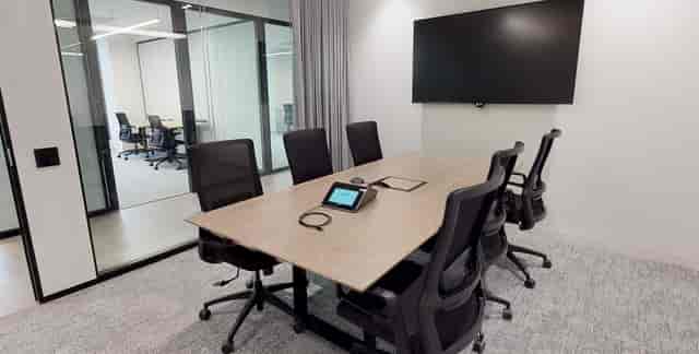 Modern conference room with glass walls for collaborative meetings at Premier Workspaces.