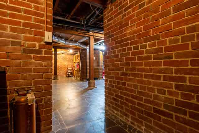 Rustic basement venue with exposed brick, perfect for intimate gatherings and unique events.