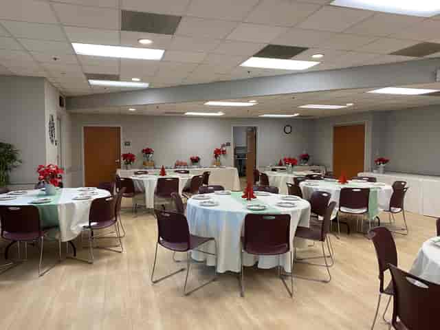 Meeting room with round tables and white tablecloths for community events and gatherings.