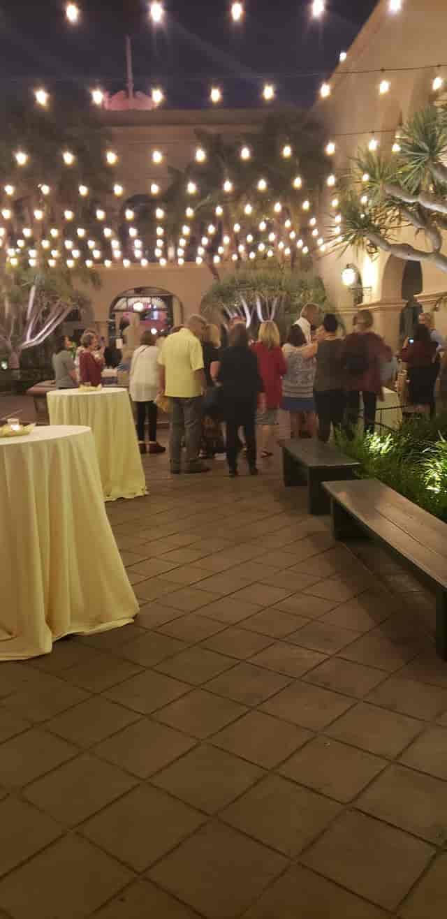 Casa del Prado in Balboa Park, outdoor networking event with warm lighting and casual seating.