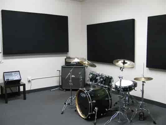 Soundproof rehearsal studio with drum set, ideal for creative workshops and team-building events.
