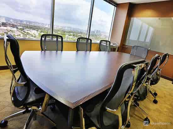 Modern conference room with triangular table, ideal for meetings and presentations.