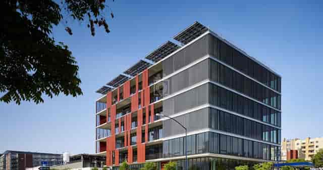 Modern eco-friendly building with glass and red accents for corporate events.