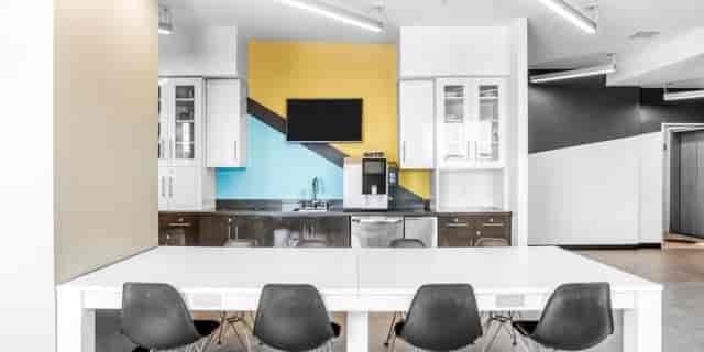 Modern coworking meeting space with a large white table, ideal for collaboration events.