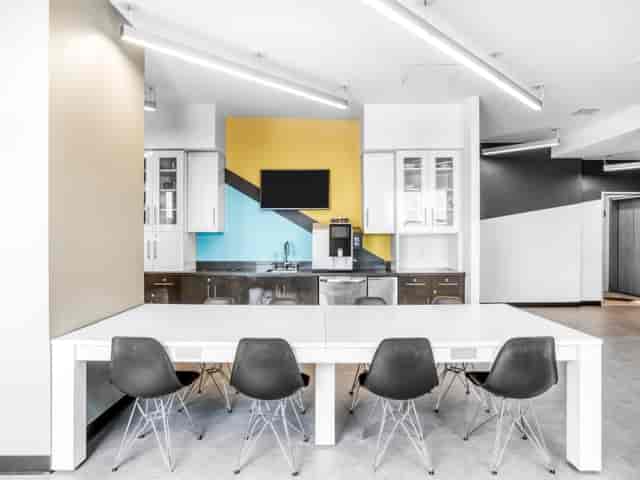 Modern coworking meeting space with sleek kitchen, ideal for collaboration and brainstorming.