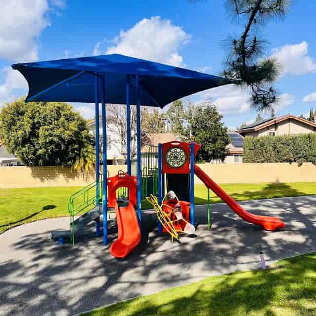 Colorful playground and picnic shelter in John S. Simms Park, perfect for family gatherings.