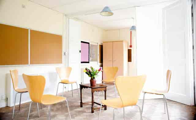 Bright Small Meeting Room with light wooden chairs for collaborative discussions.