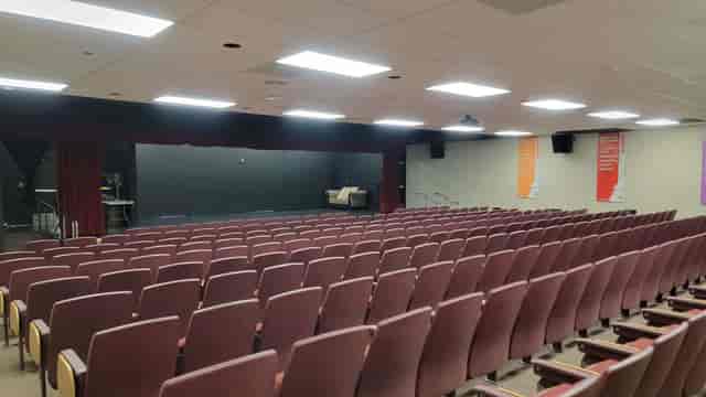 Main Auditorium in Downey Theatre with maroon seating for conferences and performances.