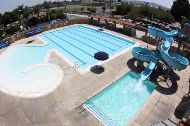 El Monte Aquatic Center outdoor pool with lanes and water slide for summer events.