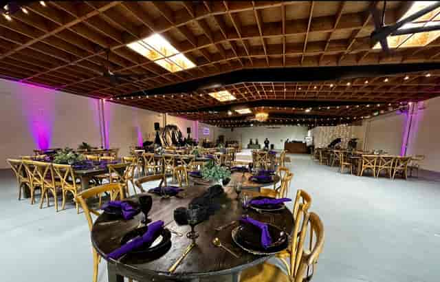 Cupcake stands in elegant event space with black and purple decor for weddings or corporate events.