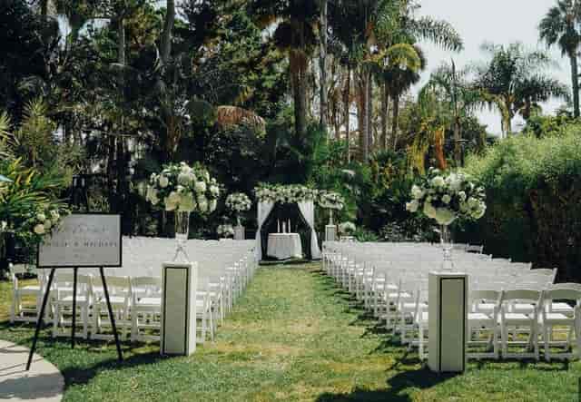 Outdoor wedding setup at Island Point Lawn with white chairs and floral arrangements.