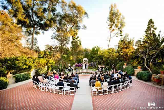 Outdoor wedding ceremony in lush garden, intimate seating, San Diego event planning.