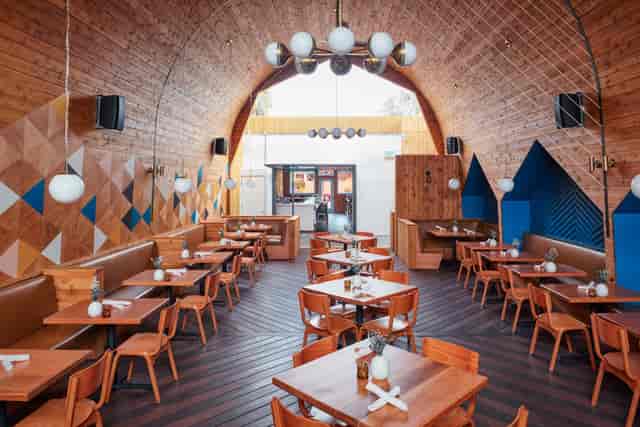 Modern restaurant interior with warm wood decor, ideal for events and gatherings.
