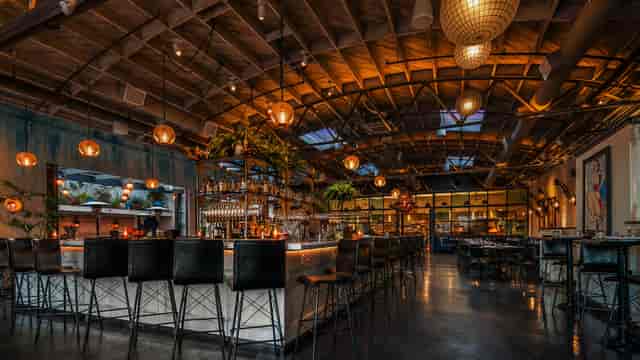 Stylish venue with inviting bar and warm lighting for events at Herb & Wood.