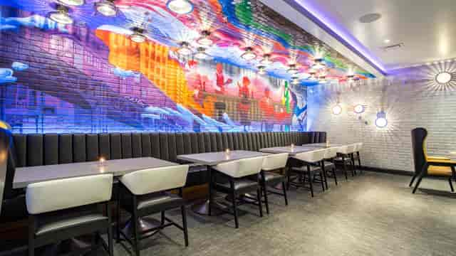 Vibrant Club Space dining area with mural, ideal for networking events and gatherings.