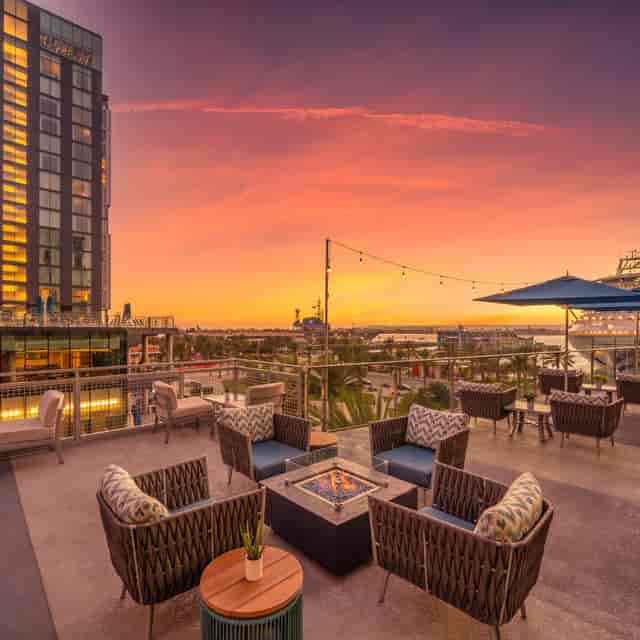 Outdoor patio event space with modern seating, sunset backdrop, ideal for gatherings.