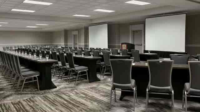 Conference room with dual screens for seminars and business meetings.