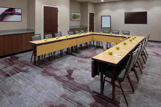 U-shaped meeting room with green accents, ideal for workshops and strategy sessions.