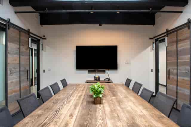 Modern meeting room with large wooden table, ideal for collaborative events and presentations.