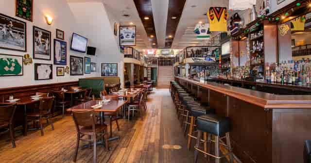 Spacious event venue with bar and sports decor for casual gatherings in The Ould Sod.