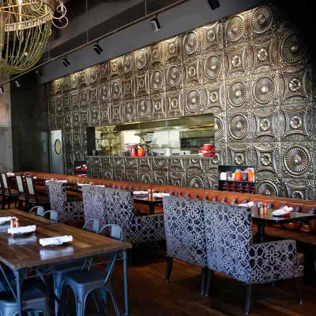 Fire Pit Lounges at Culinary Dropout, featuring a metallic wall for upscale dining events.