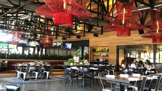 Modern event space at Culinary Dropout with red pendant lights and flexible seating.