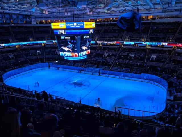 Vibrant ice hockey arena with illuminated rink and energetic crowd for corporate events.