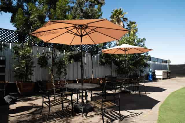 Outdoor event space with shaded seating under umbrellas, perfect for networking and meetings.