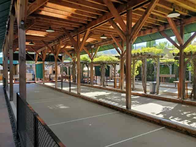 Outdoor patio with wooden beams for casual gatherings and bocce ball events.
