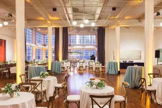 Elegant event space at TERRA Gallery with round tables and natural light for gatherings.