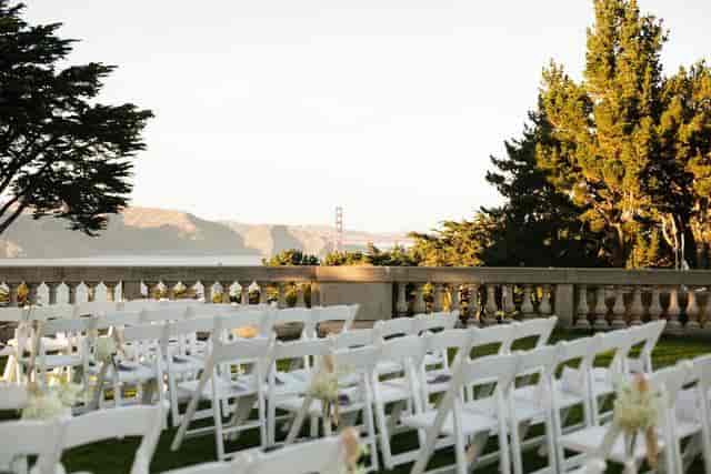 Outdoor wedding venue with white chairs and scenic backdrop at Amazáe Events.