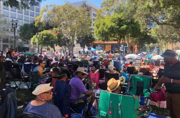 Vibrant outdoor event at City Hall Plaza, San Jose with large crowd and shaded seating.