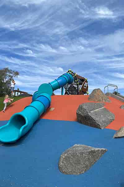 Vibrant playground with blue slide in Park de la Cruz for family-friendly events.