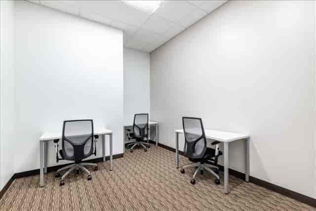 Minimalist coworking meeting space with desks for small group discussions in San Diego.