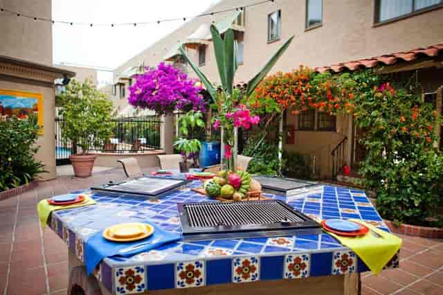 Vibrant outdoor event space at El Cordova Hotel with grill area and lush greenery.