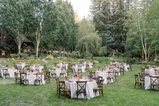 Alice in Wonderland table setup for a wedding in a lush outdoor venue.
