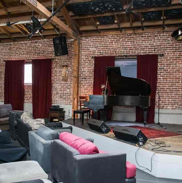 Cozy event space with grand piano, ideal for music events and private parties.