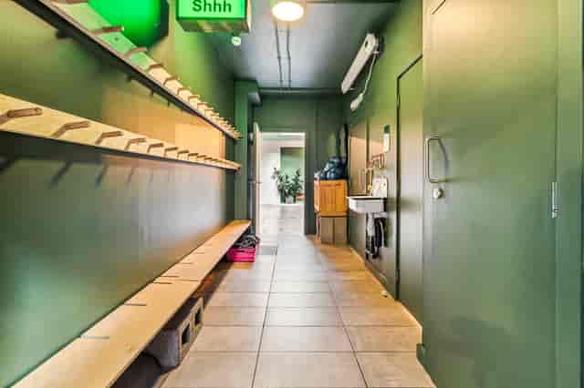 Yoga studio hallway with green walls, ideal for events and mingling.