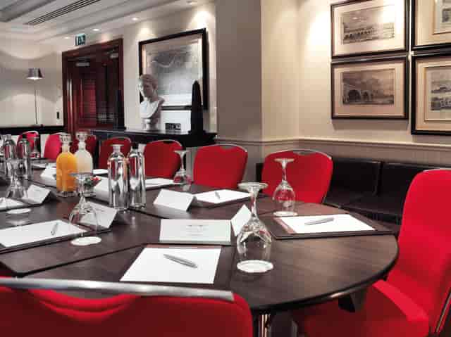 Bridge Suite meeting room at London Bridge Hotel with vibrant red chairs for corporate events.