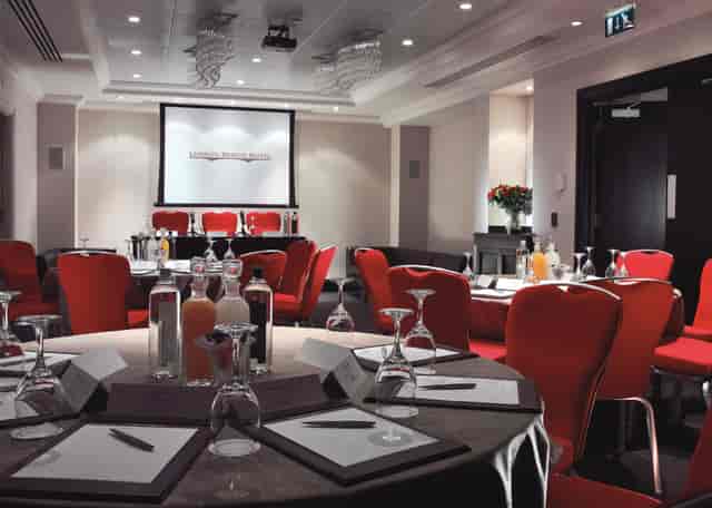 Shakespeare Suite meeting room with round tables, red chairs for corporate events.